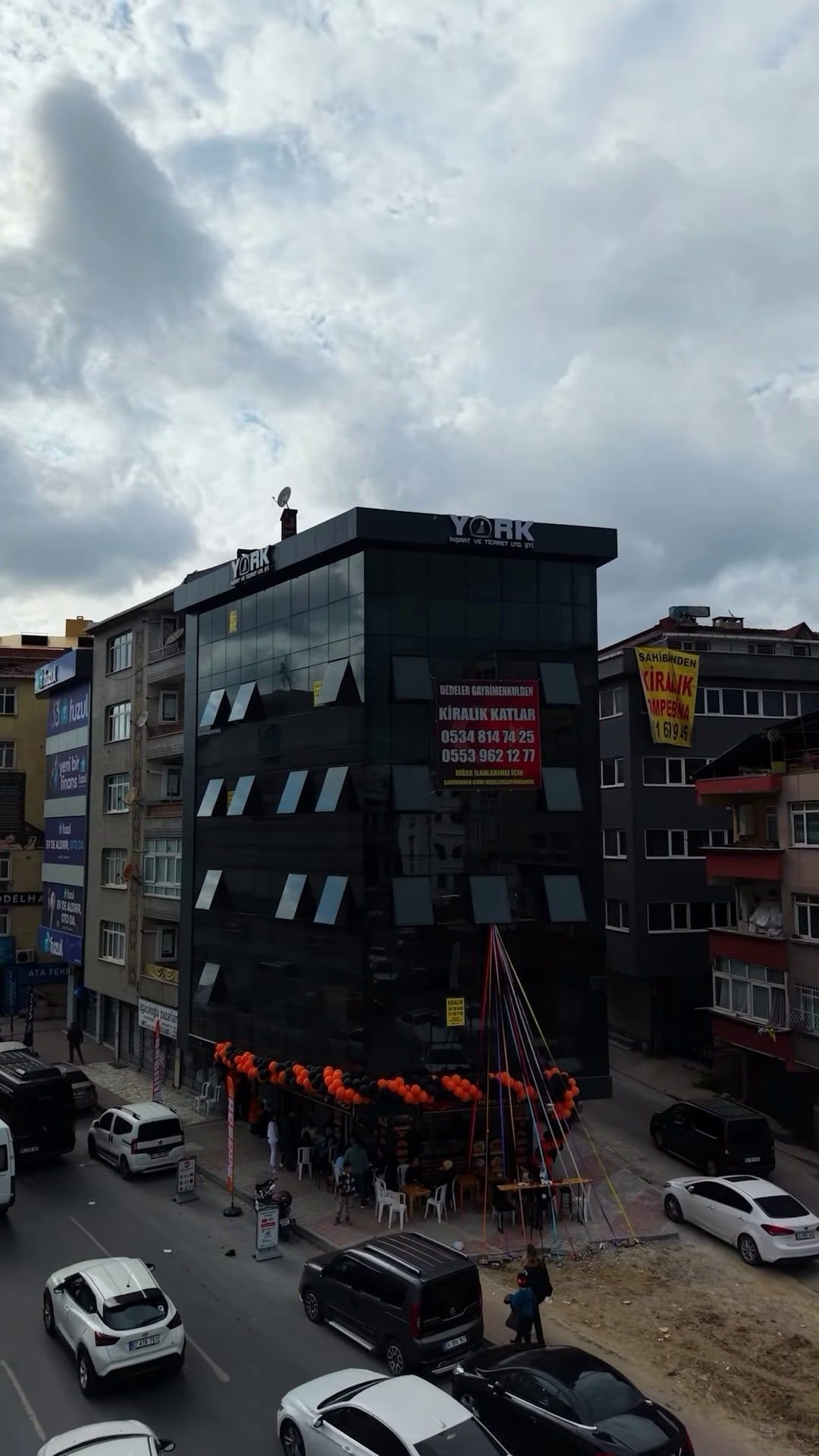 Gül İş Merkezi: koyu cam cepheli, çok katlı iş merkezi binası ve önündeki cadde