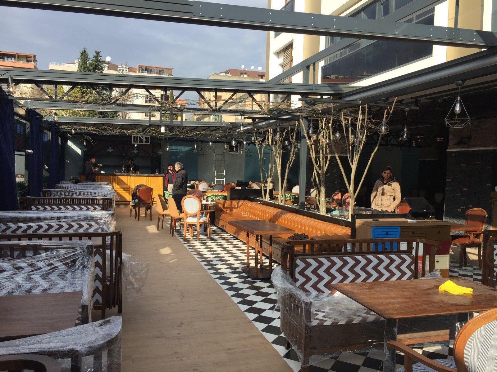 Habbe Restaurant bahçe salonunda damalı zemin ve ahşap masalar